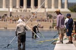 Visitors watch as National Park Service employees use vacuums to clean the Lincoln Memorial Reflecting Pool, Saturday, June 20, 2026, in Washington.