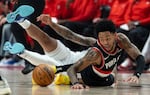 Portland Trail Blazers guard Anfernee Simons, right, dives for the ball against the Dallas Mavericks during the first half of an NBA basketball game Sunday, Dec. 1, 2024, in Portland, Ore.