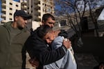 Suleiman Hamed, 14, (right) the brother of Palestinian Abdel Rahman Hamed, 18, cries wile being comforted by a relative during his funeral in the West Bank town of Silwad on Monday, Jan. 29.