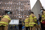 Firefighters work at the scene of a fatal fire at an apartment building in the Bronx on Sunday, Jan. 9, 2022, in New York. The majority of victims were suffering from severe smoke inhalation, FDNY Commissioner Daniel Nigro said.
