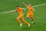 Wout Weghorst (L) of Netherlands celebrates with teammate Frenkie de Jong after scoring the team's second goal during the World Cup quarterfinal match against Argentina on December 09, 2022.