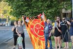 People watch a procession from Kootenai Health headed to Spokane, Wash., after two firefighters were killed Sunday when they were ambushed by sniper fire while responding to a blaze in a northern Idaho mountain community, in Coeur d’Alene, Idaho.