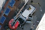 A black flag with white lettering lies on the ground rolled up behind a pickup truck that a man drove into a crowd on Bourbon Street in New Orleans, killing and injuring a number of people, early Wednesday morning, Jan. 1, 2025. The FBI said they recovered an Islamic State group flag from the vehicle.