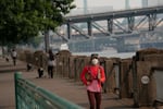 A runner wears a mask at Tom McCall Waterfront Park in Portland, Ore., on Aug. 4, 2026. The National Weather Service issued a warning that air quality will reach unhealthy levels over the next couple of days as wildfires continue to burn accross Oregon.