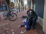 Portland Police Sgt. Jerry Cioeta checks for a pulse after giving a third round of opioid reversal medication to a man found unresponsive in downtown Portland, Ore. The man was revived.
