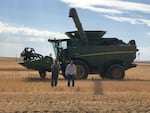 Roger Hsieh and Daniel Berg walk toward a pickup truck in the Horse Heave Hills of south central Washington during wheat harvest this year.  