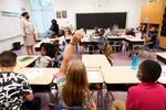A student raises their hand in a classroom at Tussahaw Elementary School in 2021 in McDonough, Ga.