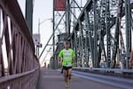 A man dashes across Portland's Hawthorne Bridge at the start of Leg 13.