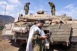 Sun., Oct. 8: An Israeli sodleir prays standing in front of a Merkava tank on the outskirts of the northern town of Kiryat Shmona near the border with Lebanon.