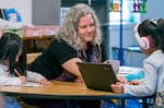 Teacher Liz Knapp, center, works with students at Newby Elementary School in McMinnville, Dec. 12, 2023. Knapp was diagnosed with autism and ADHD about a year and a half ago, and says “…one of the things I have observed about being neurodivergent is that I am hyper aware of the othering that happens in education, and really try to work against that to support students.” 