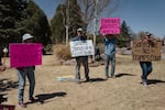 SANTA FE, NEW MEXICO - APRIL 9, 2025: Protesters (L-R) Celia Hulton, David Receconi, Richard Folks, and Carol Norris demonstrate outside the New Mexico State Capitol, known as the Roundhouse, in Santa Fe, NM on April 9, 2025. Norris founded the protest group, Resist-Rest-Repeat, two months ago. CREDIT: Adria Malcolm for NPR