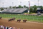 Spectators watch a horse race at Churchill Downs in Louisville, Ky., on April 30, 2025. Junior Alvarado, a jockey from Venezuela, makes his way to second place before crossing the finish line.