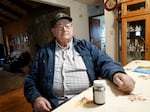 Don Porfily sits in the dining room of his Crook County farmhouse with a sample of his tap water on May 1, 2023.