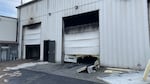 Two large metal shop garage doors with smoke damage