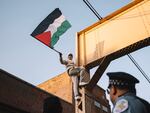 A Pro-Palestinian protester climbs a support beam near the United Center on Wednesday.