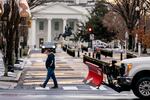 The White House is visible as a snow plow drives down K Street in Washington, Monday, Jan. 17, 2022, following a wintery mix.