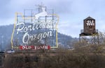 FILE - Portland’s iconic landmarks, the White Stag sign and Old Town water tower, in downtown Portland, Ore., March 26, 2024.