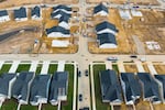 This aerial photo shows completed and under-construction new homes in Trappe, Maryland, in 2022. Some of the completed homes have green lawns. The homes still under constructions are on dirt lots.