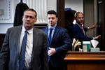 Kyle Rittenhouse, center, enters the courtroom with his attorneys Mark Richards, left, and Corey Chirafisi.