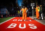 Utility worker, Vincent Edmonson, finishes the newly painted transit lane with the help of the PBOT crew.