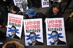 Members of the Korean Confederation of Trade Unions hold placards reading "Step down Yoon Suk Yeol who led the insurrection!" with a picture of Yoon during a rally calling for the impeachment of President Yoon Suk Yeol in front of the ruling People Power Party headquarters in Seoul on December 6, 2024.