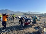 Former residents of a city-sanctioned campsite for homeless people in Grant Pass, Ore., gather their belongings as they are evicted from the site on Friday, Jan. 24, on orders of the city council. The city closed the site as unsightly and unsanitary.