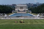 A worker mows the grass on the National Mall near the Reflecting Pool, the World War II Memorial and Lincoln Memorial, Friday, June 12, 2026.