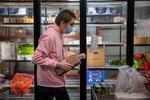 Adam Noland, a youth volunteer at the Lummi Community Service center, gathers cheese and eggs for a commodity box order.