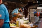 Steven Stimek, chef de cuisine for Javelina, pours verde sauce into bottles, which will be used to drizzle sauce on braised wild rabbit legs.