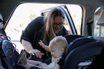 Christin Shapiro unbuckles her son Jori from his car seat before dropping him off at OSU-Cascade's Little Kits daycare in Bend, Ore., on June 23, 2026.