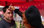 Shea Whitsett, from Portland, has his makeup done by Sierra Rockett at the Event Cosmetics booth.