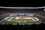 The flags of Mexico and the United States cover the field before an NFL football game between the Los Angeles Chargers and the Kansas City Chiefs Monday, Nov. 18, 2019, in Mexico City. 