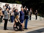 Former President Donald Trump looks on alongside Marlon Bateman (left), Marine Cpl. Kelsee Lainhart and U.S. Marine Corps Sgt. Tyler Vargas-Andrews during a wreath-laying ceremony at Arlington National Cemetery on Aug. 26 to honor the lives of those who died at the Abbey Gate bombing in Afghanistan.