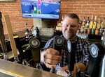 Jaramie Mykisen pours a pint of beer at the Noble Fox in Ashland.