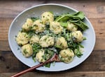 A bowl of dumplings with fresh spring greens.