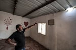 Mohamad Hassouna, 49, points to a hole in the roof of a building caused by a projectile that injured his 7-year-old daughter at their Bedouin village in the southern Negev desert on Sunday.