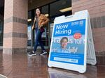 A customer walks by a "Now Hiring" sign posted in front of a store in Novato, Calif., on April 7, 2023. The labor market remains red hot. That's great for workers, but it's bound to reinforce concerns about high inflation.