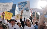 Protesters hold signs with slogans such as "Hands off it all" and "There has to be a better way. Democracy is not negotiable" at an anti-Trump rally in Los Angeles in April.