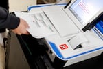 Students scan their ballots in a tabulator Chief Deputy Clerk Abe Dane brought into a class to educate students on the election process at Reading High School on Oct. 4, 2024 in Hillsdale, Mich.