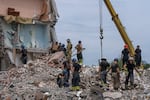Rescue workers sift through rubble on Sunday after a Russian rocket attack destroyed an apartment building in Chasiv Yar, Ukraine. At least 15 people were killed, and officials are searching for survivors.