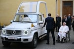 Pope Francis (right) looks on as he's presented a new fully electric popemobile at the Vatican on Wednesday.