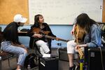 Tran Nguyen, center, smiles after writing a song with her band at the Pass the Mic workshop in Portland, Ore., Wednesday, July 31, 2019. The workshop connects experienced local musicians with immigrant and refugee youth.