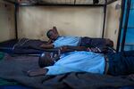 Paris (front) and Saidimu relax on their beds at the dormitory.