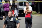 FILE: A parent hugs his daughter after she arrived with other students at a shopping center parking lot in Wood Village, Ore., after a shooting at Reynolds High School on June 10, 2014, in nearby Troutdale. A gunman killed a student at the high school.