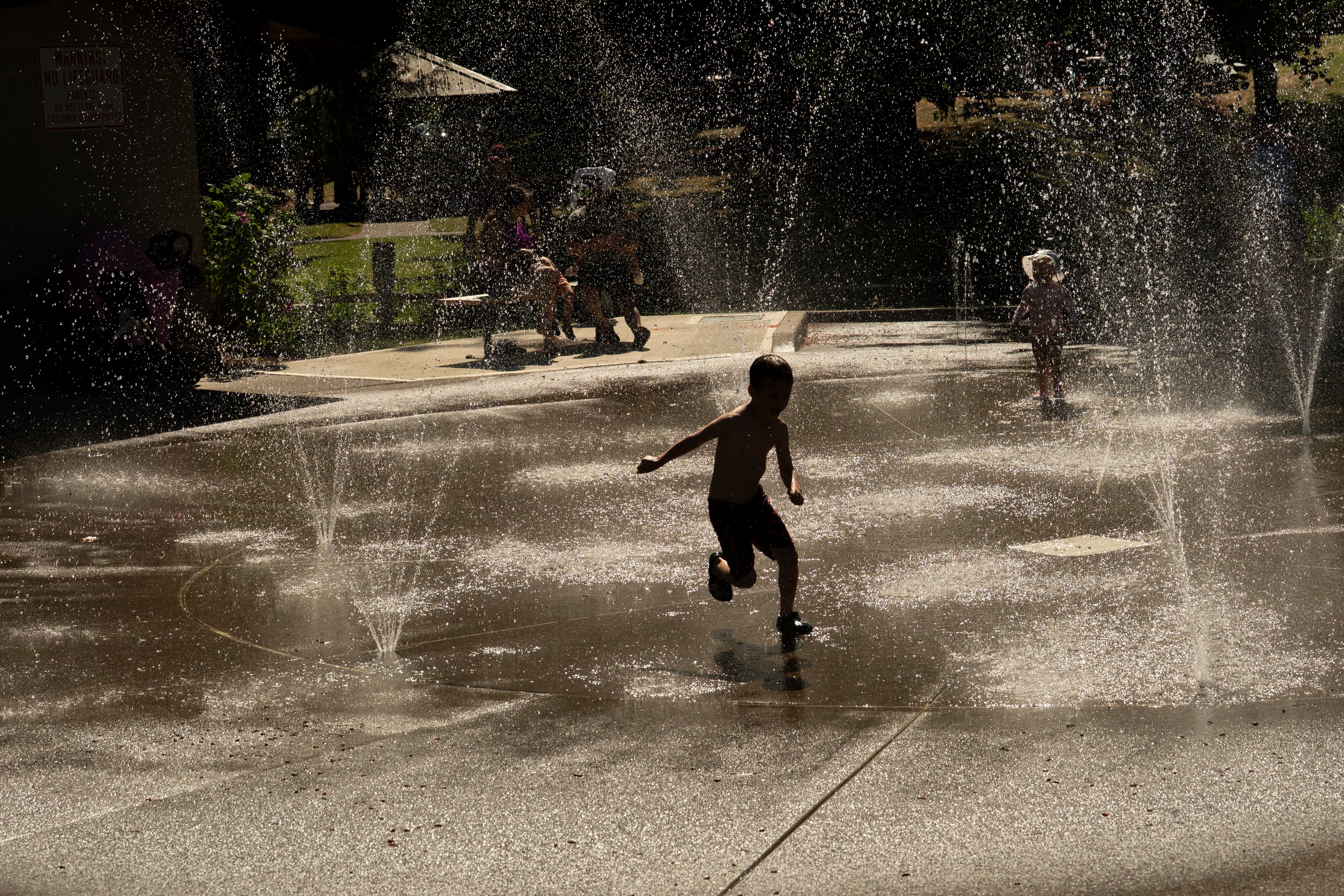 A child plays at the splash pad at Willamette Park in West Linn, Ore., on June 13, 2026.