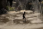 A child plays at the splash pad at Willamette Park in West Linn, Ore., on June 13, 2026.