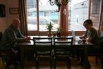 Skylar Isaacs (right) takes online classes as a high school junior at one end of the dining room table. His father Steven often sits across from him.