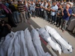 Mourners pray over the bodies of Palestinians who were killed in an Israeli airstrike in Nuseirat, at the Al Aqsa hospital in Deir al Balah, Gaza Strip, Sunday, May 19, 2024.