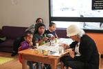Children paint watercolors with a Rosewood volunteer while their mothers do Zumba.