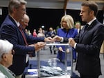 French President Emmanuel Macron, right, votes for the second round of the legislative elections in Le Touquet-Paris-Plage, northern France, on Sunday. 